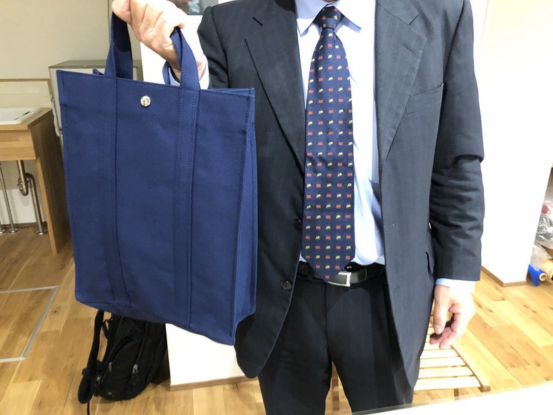 8号帆布で製作したネイビーのオーダートートバッグを手に持っている様子。