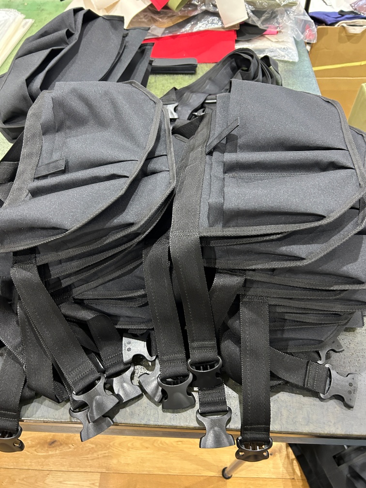 コーデュラ610P製清掃員専用オリジナルウエストポーチの検品作業、バックルや縫製状態を確認する工程