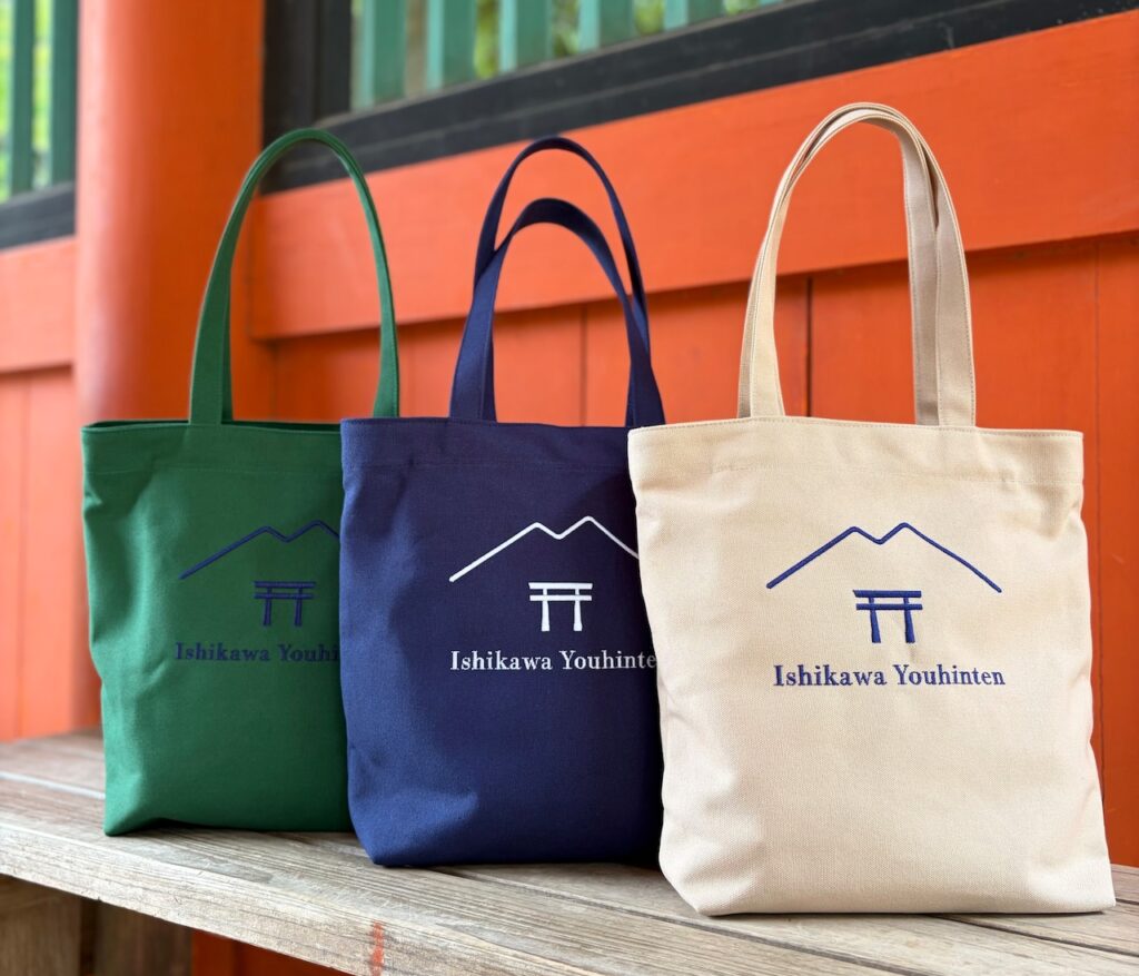 石川洋品店様のオリジナル刺繍入り帆布トートバッグ。御朱印帳が収納できる内ポケット付きで、ベージュ・ネイビー・グリーンの3色を展開。